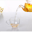 Chaleira de vidro com infusor 800ml sobre chama de fogão com chá borbulhando - Casa Splêndida