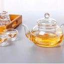 Chaleira de vidro com infusor 800ml sobre chama de fogão com chá borbulhando - Casa Splêndida