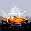 Chaleira de vidro com infusor 800ml sobre chama de fogão com chá borbulhando - Casa Splêndida