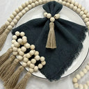 Porta-guardanapo artesanal com contas de madeira natural e tassel de juta – estilo boho e rústico para mesa posta elegante.