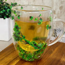Caneca de vidro parede dupla com flores e folhagens verdes naturais e bebida quente - Casa Splêndida