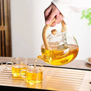 Chaleira de vidro 1L com infusor e alça de bambu natural, servida com chá em ambiente aconchegante - Casa Splêndida