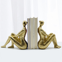 Escultura decorativa abstrata para estantes e mesas, com design moderno e acabamento bronze sofisticado.