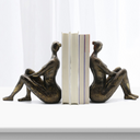 Escultura decorativa abstrata para estantes e mesas, com design moderno e acabamento bronze sofisticado.