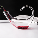 Decanter de cristal com copos para vinho, em mesa sofisticada. Ideal para servir e decorar com elegância.