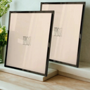 Kit com 2 porta-retratos 15x20 em aço inox e vidro, disponível nas cores rose, dourado, prata ou grafite, design moderno.