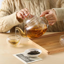 Chaleira de vidro com infusor 800ml sobre chama de fogão com chá borbulhando - Casa Splêndida