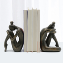 Escultura decorativa abstrata para estantes e mesas, com design moderno e acabamento bronze sofisticado.