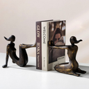 Escultura decorativa abstrata para estantes e mesas, com design moderno e acabamento bronze sofisticado.