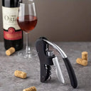 Abridor de Vinho e Saca-Rolhas com Alavanca Premium Casa Splendida preto em close, com rolhas ao fundo sobre superfície de pedra elegante.