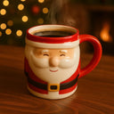 Caneca de Natal em cerâmica Papai Noel cheia de bebida quente, apoiada sobre mesa de madeira, com fundo natalino iluminado.