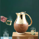 Garrafa térmica decorativa com acabamento dourado e corpo com efeito madeira elegante