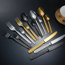 Faqueiro Grand Élysée com talheres prata, dourado e preto em composição elegante sobre fundo escuro sofisticado.