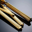 Close-up das hastes dos talheres do Faqueiro Royale Luxo em prata e dourado, destacando o acabamento estriado.