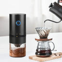 Moedor de café elétrico portátil preto com botão liga/desliga e copo transparente para café moído