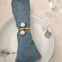 Porta-guardanapo de metal dourado com pérolas artificiais – Casa Splendida, ideal para casamentos e jantares elegantes.