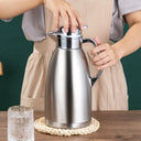 Garrafa térmica Roman inox prata servindo água quente com tampa de botão e alça ergonômica