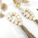 Porta-guardanapo artesanal com contas de madeira natural e tassel de juta – estilo boho e rústico para mesa posta elegante.