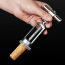 Mão utilizando o saca-rolhas inox vintage Casa Splendida para retirar a rolha da garrafa de vinho de forma prática e segura.