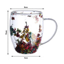 Caneca de vidro duplo com flores secas coloridas e bebida quente sendo servida - Casa Splêndida