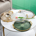Bandeja acrílica redonda com alça dourada, disponível em verde, âmbar, cinza e transparente, para decoração e organização Casa Splendida.