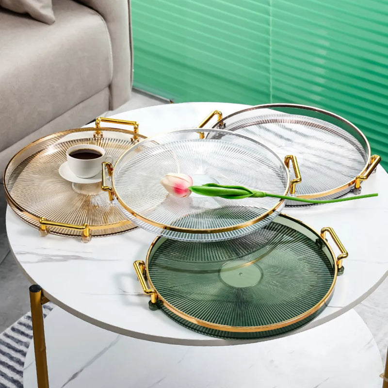 Bandeja acrílica redonda com alça dourada, disponível em verde, âmbar, cinza e transparente, para decoração e organização Casa Splendida.