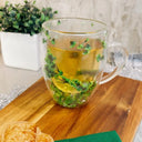 Caneca de vidro parede dupla com flores e folhagens verdes naturais e bebida quente - Casa Splêndida