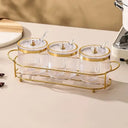 kit com três potes canelados transparentes com aro dourado, colheres e suporte metálico dourado – Casa Splendida