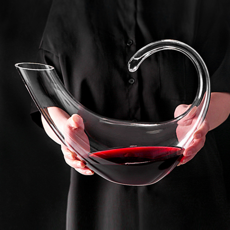 Decanter de cristal com copos para vinho, em mesa sofisticada. Ideal para servir e decorar com elegância.