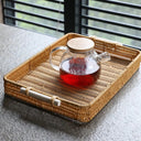 Bandeja retangular estilo rattan tecido à mão, com alça de madeira e estrutura firme Casa Splendida.

