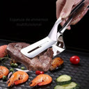 Pinça 3-em-1 em aço inox segurando e virando bife na frigideira – Casa Splendida