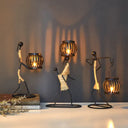 Castiçal escultura em ferro com figura abstrata e porta‑vela em forma de gaiola