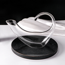 Decanter de cristal com copos para vinho, em mesa sofisticada. Ideal para servir e decorar com elegância.