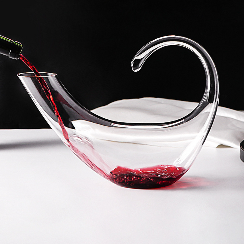 Decanter de cristal com copos para vinho, em mesa sofisticada. Ideal para servir e decorar com elegância.