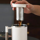 Canecas térmicas com design moderno em branco e bege, ideais para café ou cappuccino, com tampa e alça ergonômica