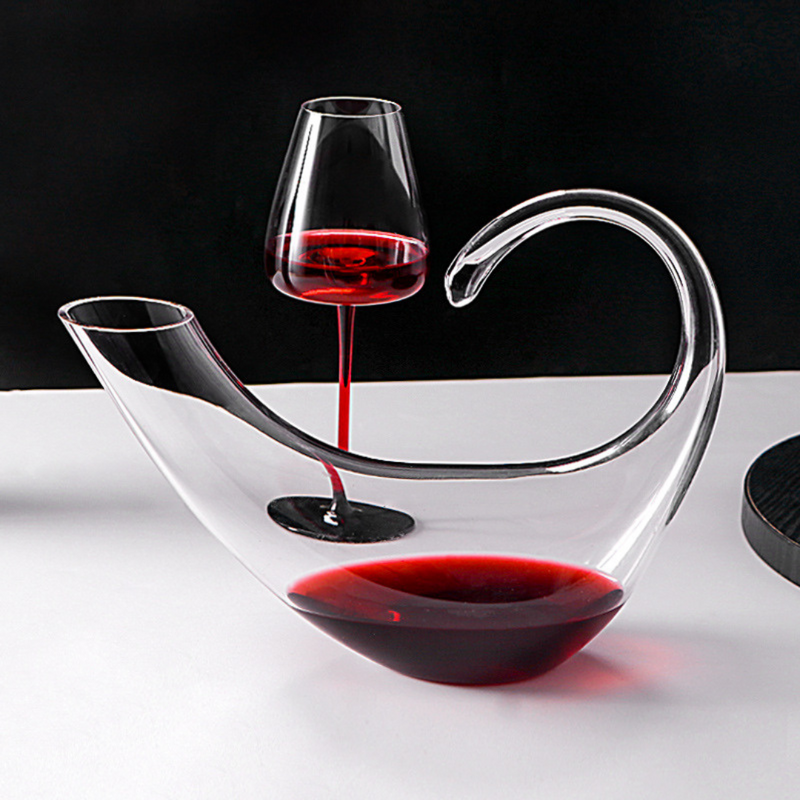 Decanter de cristal com copos para vinho, em mesa sofisticada. Ideal para servir e decorar com elegância.