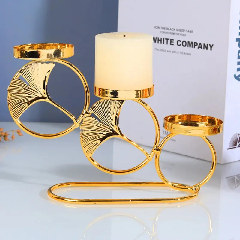 Castiçal dourado duplo com design de círculos e detalhes folheados sobre mesa