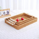 Bandeja retangular estilo rattan tecido à mão, com alça de madeira e estrutura firme Casa Splendida.


