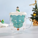 Caneca de Natal Casa Splendida transparente em vidro borossilicato, posicionada entre enfeites natalinos para foto promocional.