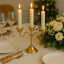 Mesa posta refinada com candelabro dourado, velas altas e arranjo floral branco, decoração Casa Splendida.
