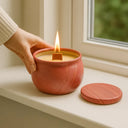 Vela aromática de capim limão acesa em recipiente decorativo vermelho com pavio de madeira – Casa Splendida
