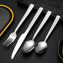 Conjunto de talheres prateados com design estriado, posicionado ao lado de xícara elegante – perfeita harmonia para servir com estilo.