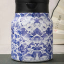 Garrafa térmica azul floral em fundo claro, produto em destaque