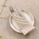 Guardanapo de linho bege em mesa posta elegante com prato decorado