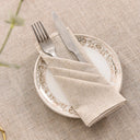 Guardanapo de linho bege em mesa posta elegante com prato decorado