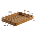 Bandeja plástica com alça e textura rattan em três tamanhos sobre superfície de madeira