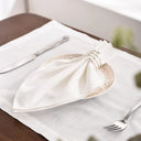 Guardanapo de linho bege em mesa posta elegante com prato decorado