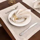 Guardanapo de linho bege em mesa posta elegante com prato decorado