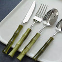 Talheres de inox com cabo em resina bambu sobre prato branco, conjunto premium para mesa posta sofisticada.