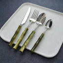 Talheres de inox com cabo em resina bambu sobre prato branco, conjunto premium para mesa posta sofisticada.